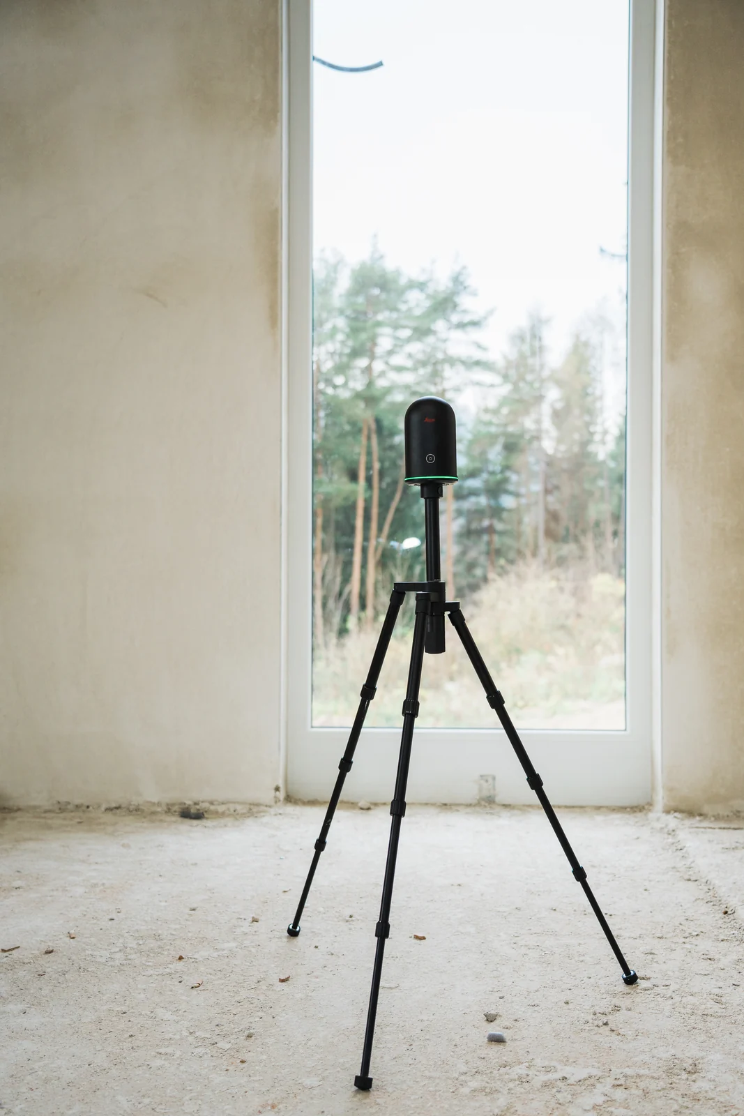 Leica BLK360 auf Stativ bei der 3D-Laseraufnahme eines Gebäudes